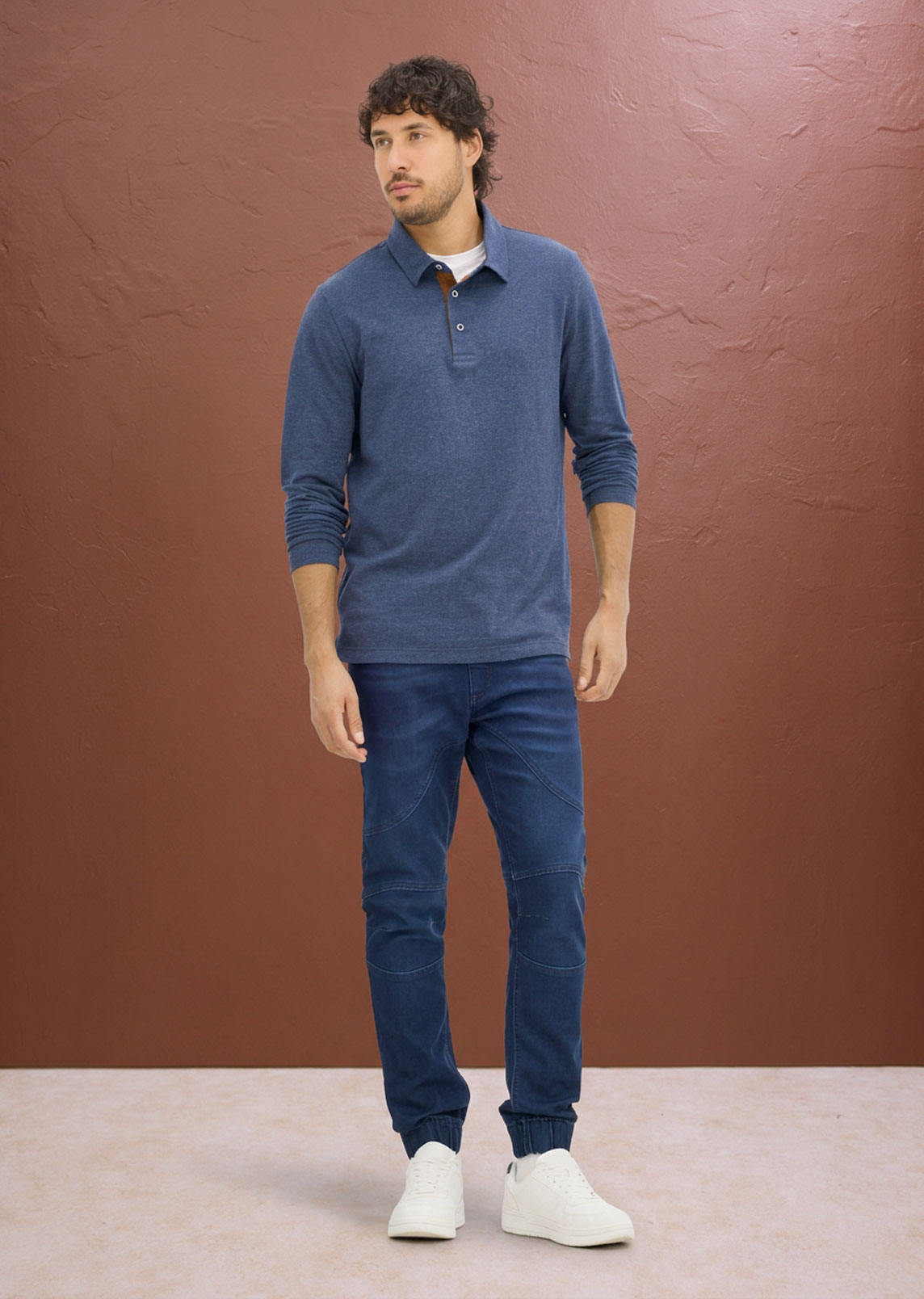 Blaues Langarm-Poloshirt, bequeme Jogger-Jeans und weiße Sneaker. Lässiger Stil.