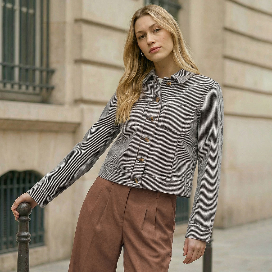 Schwarz gestreifte Übergangsjacke kombiniert mit brauner Hose.