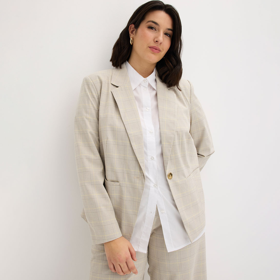 Beiger Blazer kombiniert mit klassischem weißem Hemd.