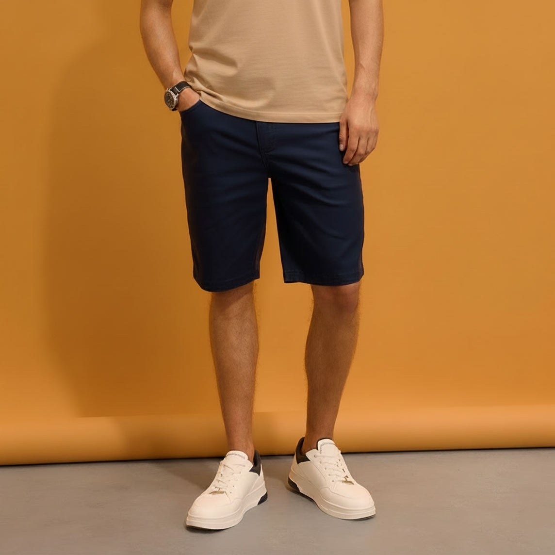 Beiges T-Shirt, dunkelblaue Shorts und weiße Sneaker.