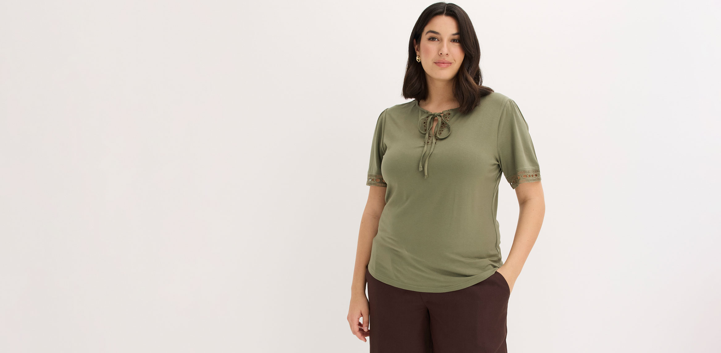 Olivgrünes T-Shirt kombiniert mit brauner Hose.