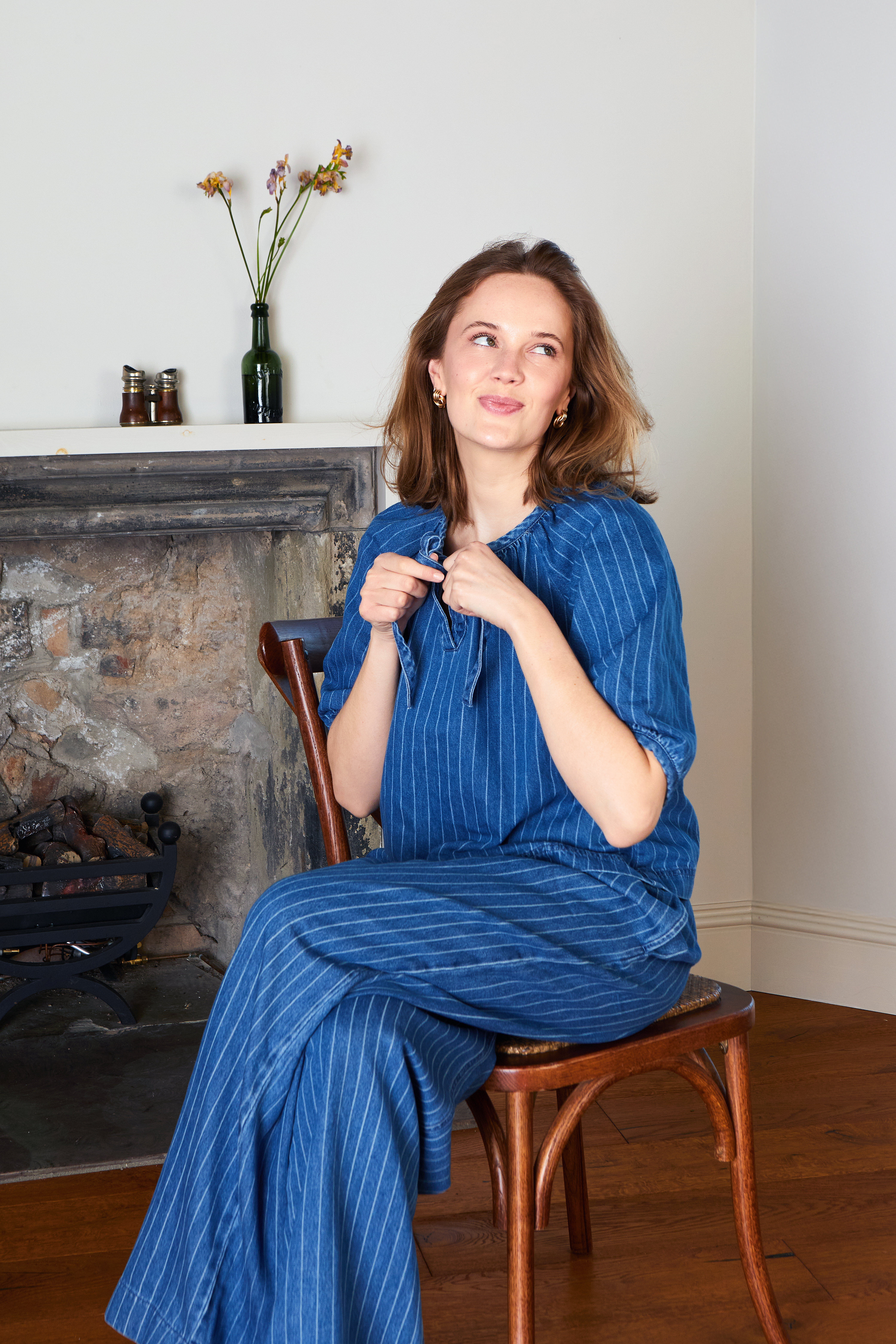 Ein blaues, gestreiftes Shirt und Jeans mit weiten Beinen.