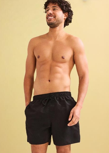 Ein Mann trägt schwarze Badehose.
