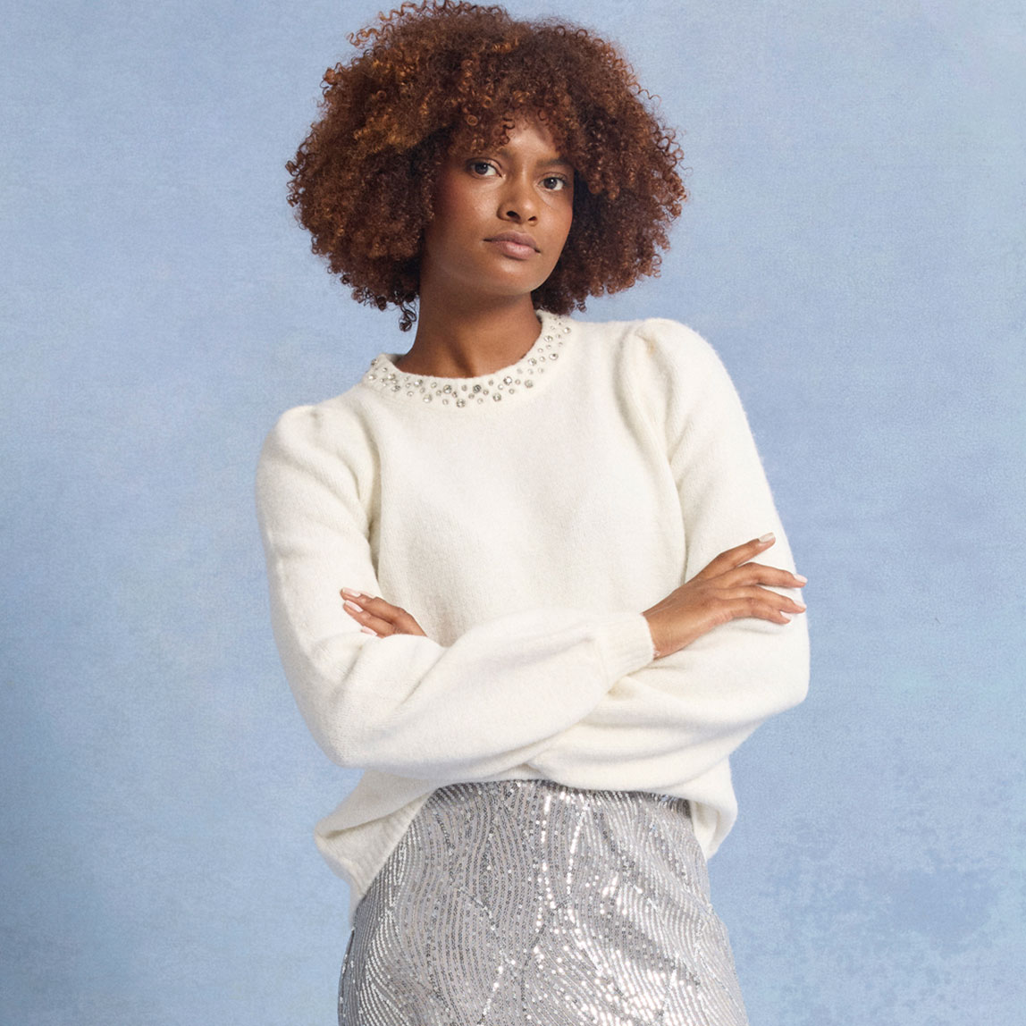 Weißer Pullover mit Spitzenkragen, kombiniert mit einem glitzernden silbernen Rock.