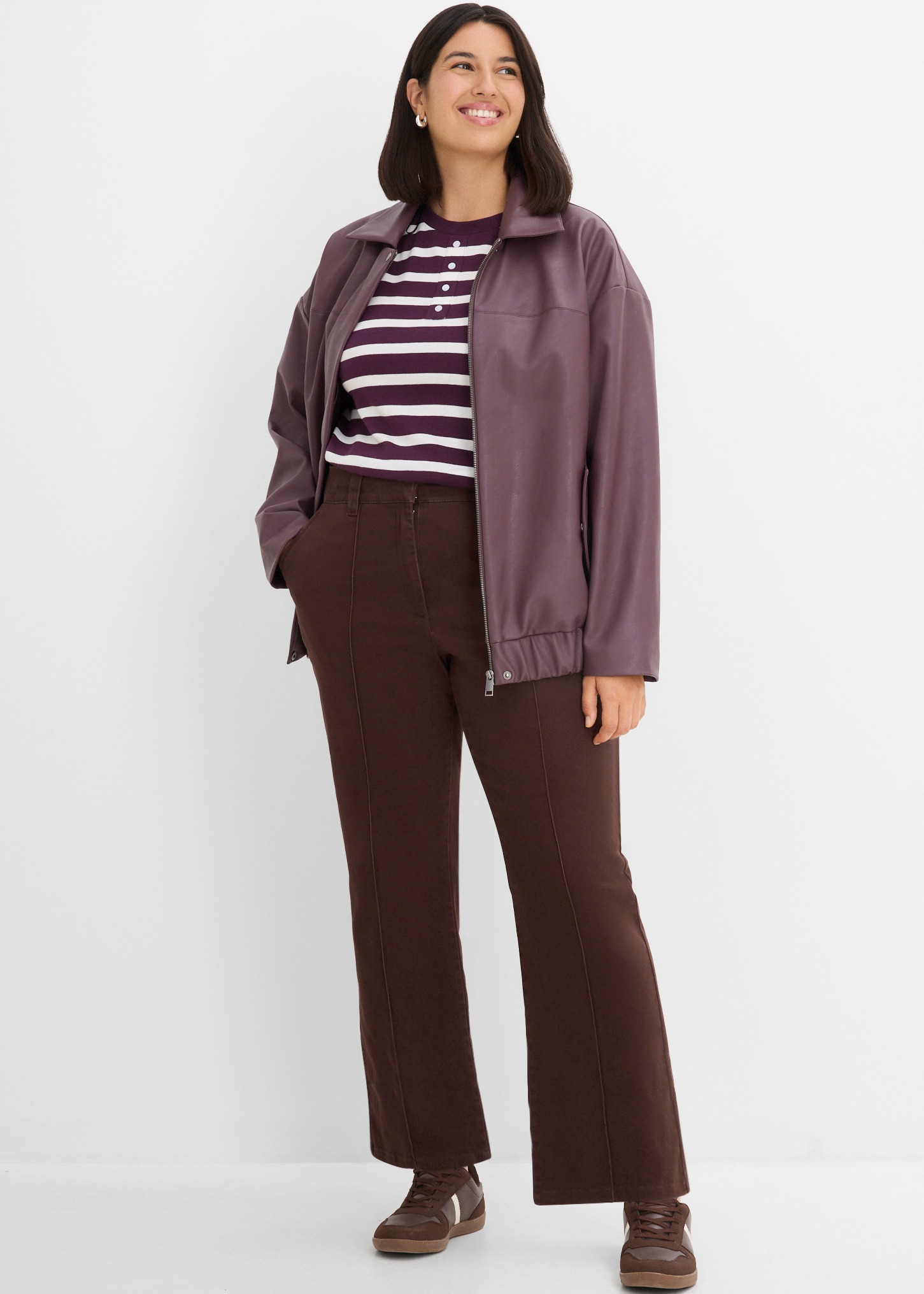 Violette Jacke, gestreiftes Shirt, braune Hose und dazu passende Sneaker.