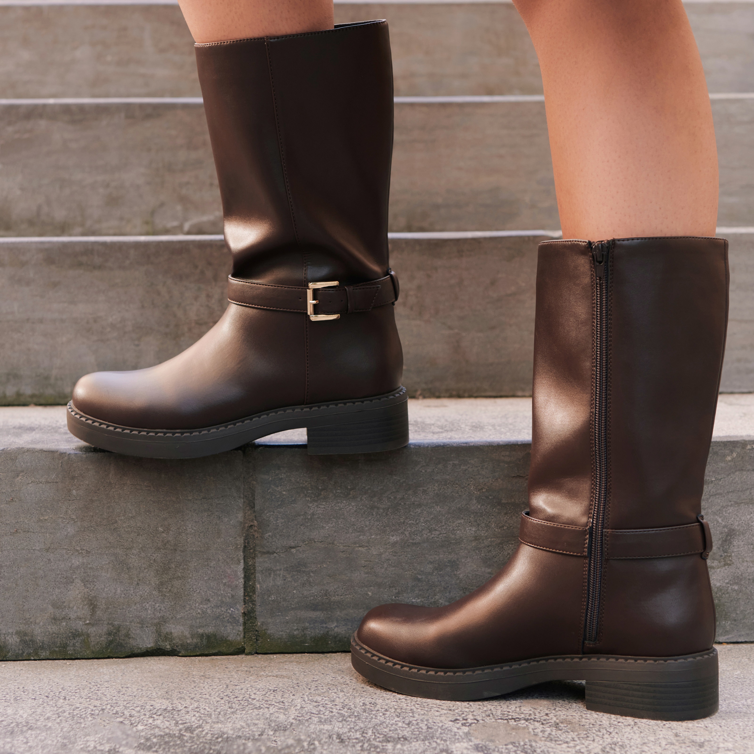 Klassische braune Stiefel mit Riemen und goldener Schnalle. Ideal für kühle Tage.